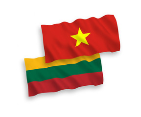 National vector fabric wave flags of Lithuania and Vietnam isolated on white background. 1 to 2 proportion.