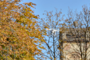 A quadrocopter flies in the city and takes photos and videos from high in the sky.
