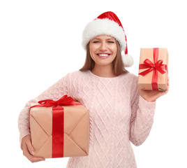 Happy young woman in Santa hat with Christmas gifts on white background