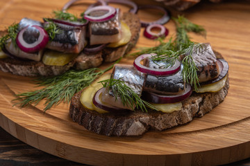 Close up traditional Russian snack-sandwich with herring, bread and onions. Selective focus