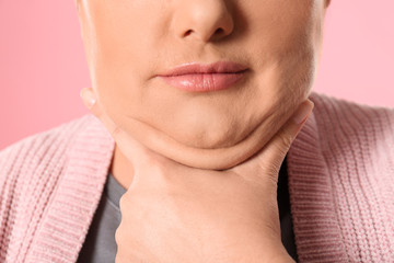Woman with double chin on pink background, closeup