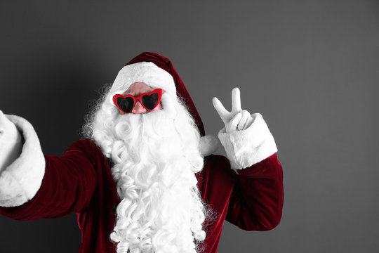 Authentic Santa Claus taking selfie on grey background