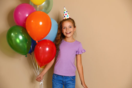 Happy Girl With Balloons On Brown Background. Birthday Celebration