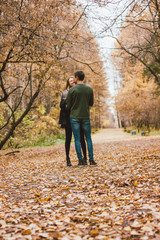 Young couple in love friends dressed in casual style walking together on autumn park