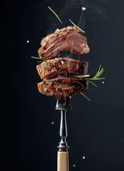 Foto auf Acrylglas Essen Gegrilltes Ribeye Beefsteak mit Rosmarin auf schwarzem Hintergrund.
