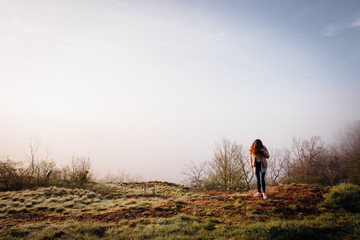 une jeune fille se promène vers une falaise. Une femme regardant un paysage brumeux. Une...