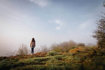 une jeune fille se promène vers une falaise. Une femme regardant un paysage brumeux. Une...