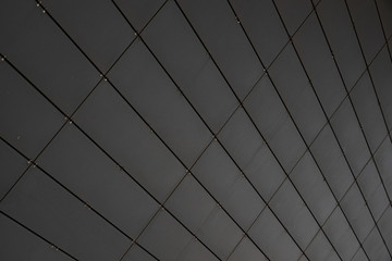 Diagonal view of grey metal wall of a building made of small metal rightangled sheets