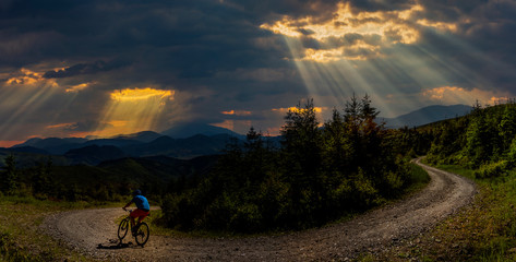 Cycling man riding on bike at sunset mountains forest landscape. Cycling MTB enduro flow trail...