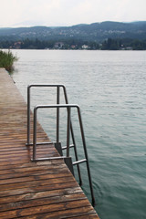 Fototapeta premium A wooden pier at Worthersee in Austria on a cloudy day
