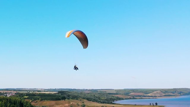 Tandem flight on the paraglider above the fields