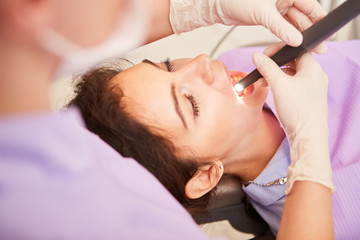 Patientin mit Zahnschmerzen wird mit Bohrer behandelt