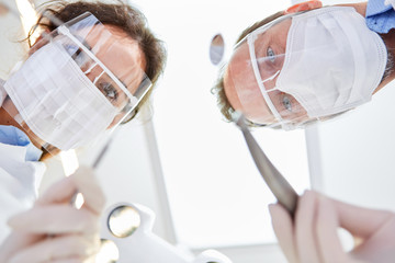 Ärzteteam mit Mundschutz und Visier vor einer OP