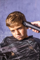 Little boy getting a haircut with a cutting machine