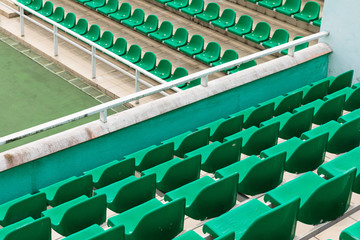 Rows of green diagonal spectator seats with no people in it