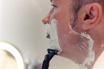Close-up of man shaving in the morning.