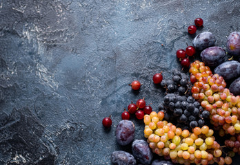 grapes gooseberries plums on a blue background harvest fruit juicy