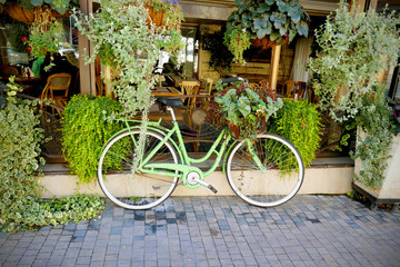 Fototapeta na wymiar Vintage green bicycle with basket full of flowers