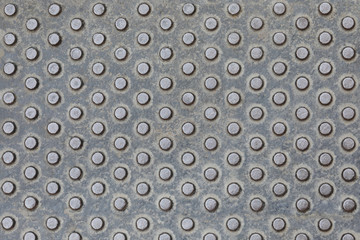 Metallic texture belonging to some street furniture. Worn metal texture with detail. Metal stamping texture. grey metal Background. Seamless pattern for construction, building material design.