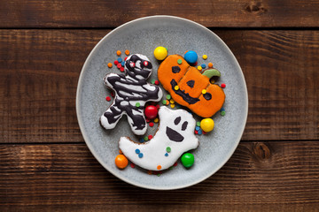 Halloween cookies: pumpkin, bat, skeleton, cast on wooden texture, flatlay