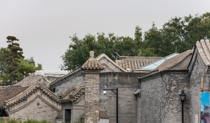 Fototapeta premium Traditional old houses in the old alley (Hutong) of old Beijing, built with bricks and black tiles.