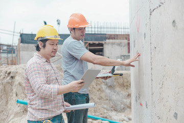 Obraz na płótnie Canvas Two young man architect on a building construction site