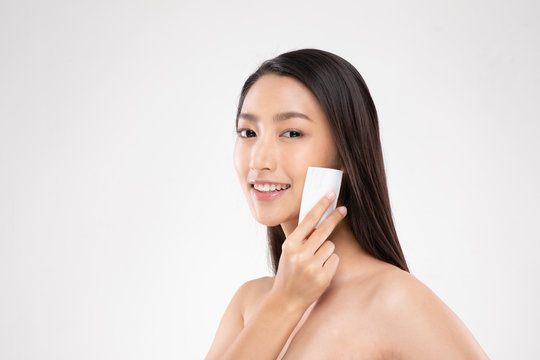Attractive Charming Asian young woman smile and using tissue with toner for cleaning make up feeling so fresh and clean with healthy skin,isolated on white background,Beauty Cosmetics Concept