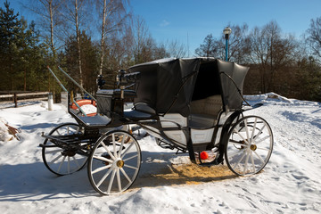 Fototapeta na wymiar The carriage on the farm is on the street on a winter day