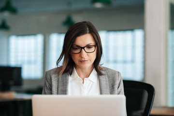 Focused businesswoman sitting at her desk working on a laptop