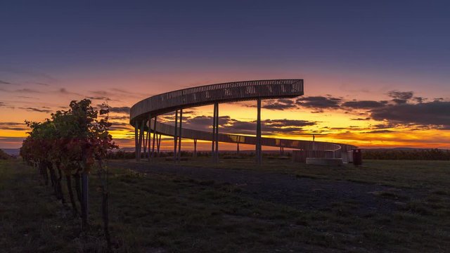 Time-lapse captured at Kobyli lookout point A wooden spiral construction in the South Moravia region during sunset with moving clouds and views of the exuberant farms and fields.