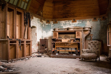 une salle abandonnée avec un vieux piano et un vieux fauteuil