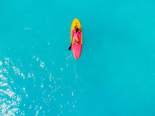 Attractive woman on stand up paddle board on a quiet blue ocean. Sup surfing in sea