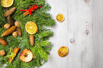 New Year's holiday decorations. Handmade Christmas wreath of fir branches with nuts, cinnamon and dried fruits dusted with artificial snow. 