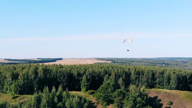 Forest landscape with a paraplane floating over it