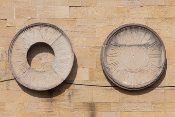Watch dials attached to a stone wall