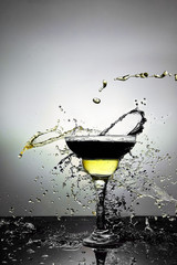 Glass with blue and yellow  champagne or cocktail. Levitation