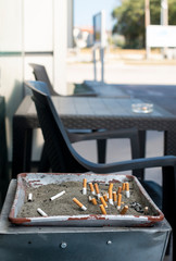 Ashtray with sand and buried cigarettes.