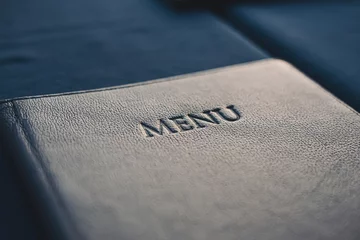 Fotobehang Dark blue menu book on table in restaurant, selective focus © hdesert