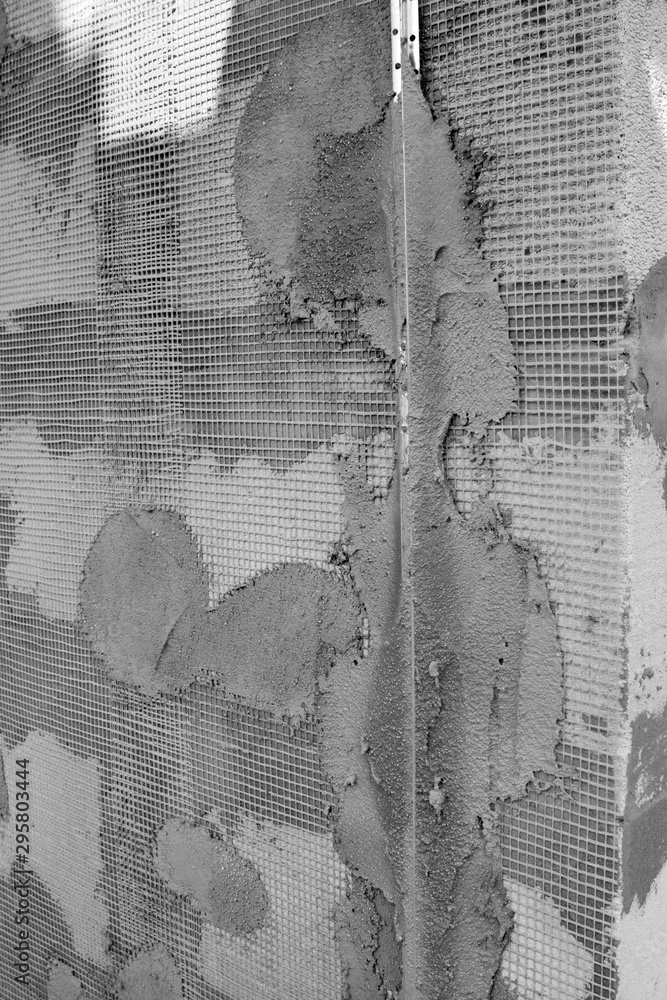 Poster surface of wall with applied construction grid and guides for plaster application