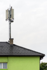 Fototapeta na wymiar 5G antennas on top of house. Antennas and transmitters on roof.