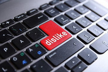 Close-up view on conceptual notebook keyboard - dislike (red key,button)