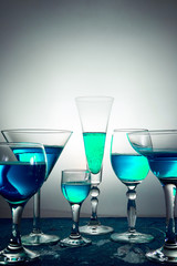 Many glasses with blue champagne or cocktail.