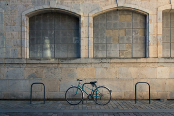 Fototapeta na wymiar Un vélo posé contre une barrière dans une ville