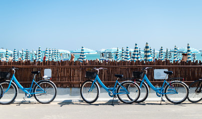 Rental bikes on the beach. Blue bicycles on the street.