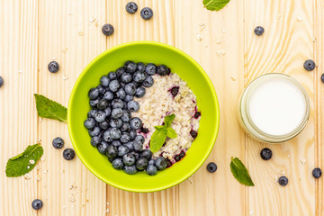 Oatmeal porridge with fresh blueberry, mint leaves and yogurt
