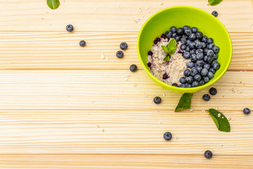 Oatmeal porridge with fresh blueberry, mint leaves and yogurt