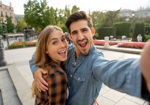 Stylish tourist couple taking pictures selfie on smart phone on romantic trip around Europe