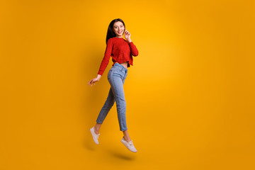 Fototapeta na wymiar Full length photo of positive cheerful satisfied girl jump have free time with her friends go walk enjoy autumn holidays wear trend outfit isolated over yellow color background