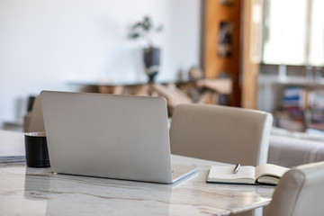 Laptop and notebook sitting on an apartment table