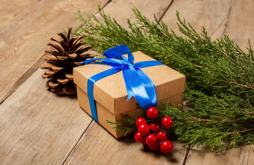 Fototapeta na wymiar Several gift boxes, Christmas decorations, Christmas tree branch on a wooden background. The concept of Christmas, winter holidays, new year. Flat lay, top view
